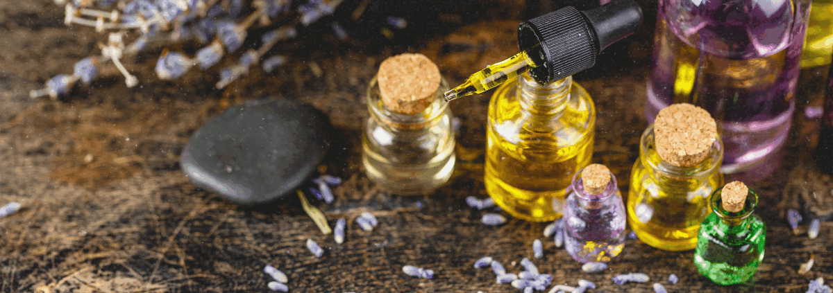 Ätherische Öle in kleinen Glasfläschchen mit Räucherwerk und Kerzen für die spirituelle Praxis während der Rauhnächte