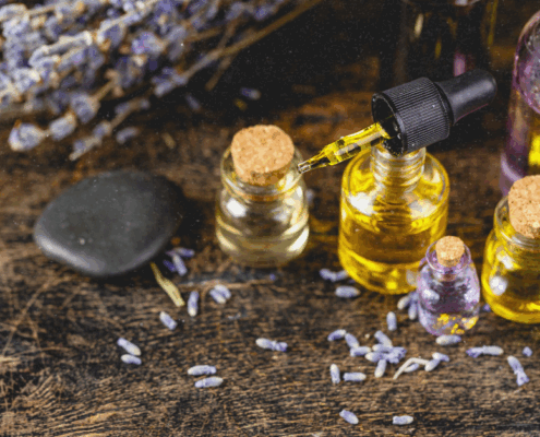 Ätherische Öle in kleinen Glasfläschchen mit Räucherwerk und Kerzen für die spirituelle Praxis während der Rauhnächte