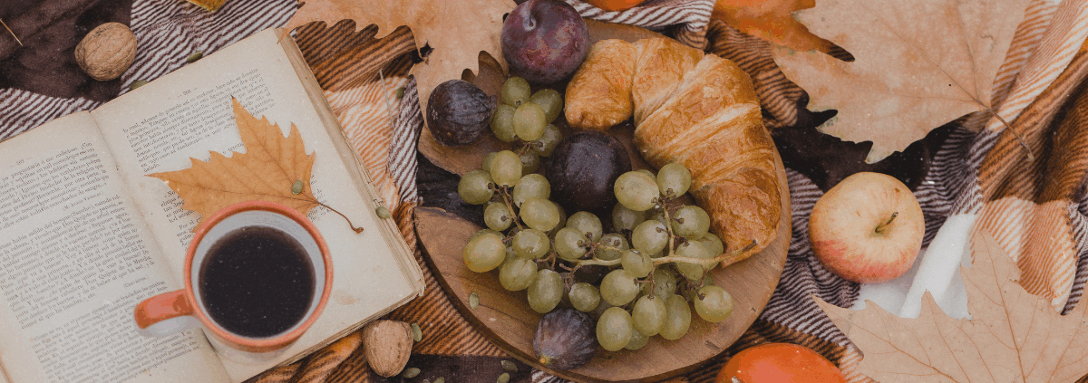 Mabon Ritual mit Buch, Herbstblättern, Äpfeln und Kürbis zur Herbst-Tagundnachtgleiche