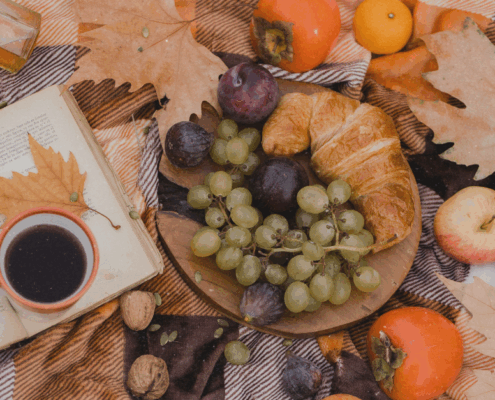 Mabon Ritual mit Buch, Herbstblättern, Äpfeln und Kürbis zur Herbst-Tagundnachtgleiche