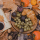 Mabon Ritual mit Buch, Herbstblättern, Äpfeln und Kürbis zur Herbst-Tagundnachtgleiche