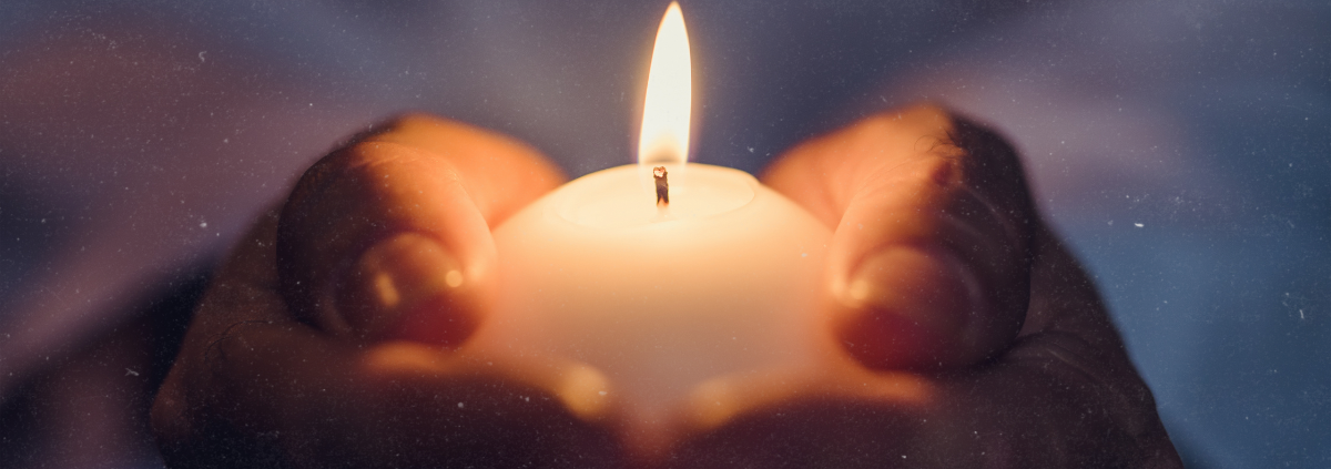 Wintersonnenwende feiern: Kerze in Händen unter Sternenhimmel symbolisiert die Rückkehr des Lichts