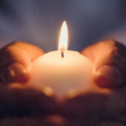 Wintersonnenwende feiern: Kerze in Händen unter Sternenhimmel symbolisiert die Rückkehr des Lichts