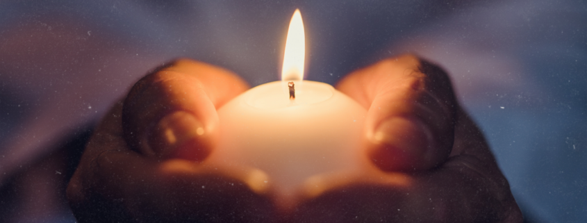 Wintersonnenwende feiern: Kerze in Händen unter Sternenhimmel symbolisiert die Rückkehr des Lichts