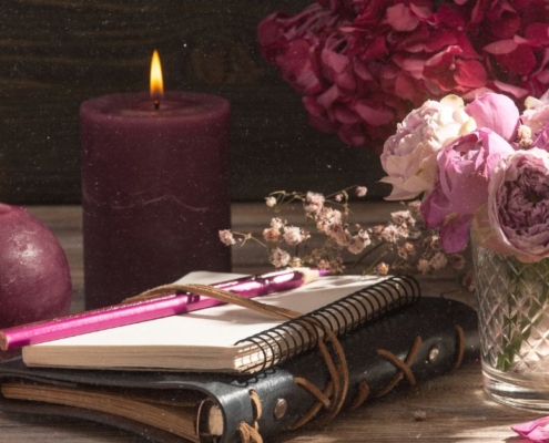 Rauhnächte FAQ 2025: Journal mit Stift und Kerzen für Reflexion und Fragen