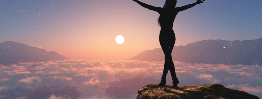 Frau mit ausgebreiteten Armen bei Sonnenaufgang über den Wolken - Venus in Erdferne symbolisiert innere Freiheit und Erneuerung im Januar 2026