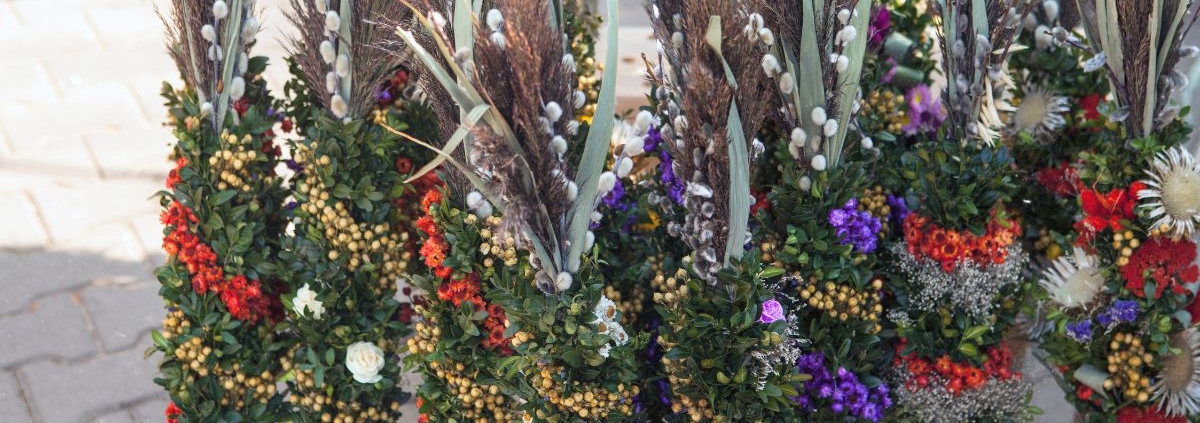 Palmsonntag Bedeutung: traditionelle Palmbuschen mit Palmkätzchen und Frühlingsblumen
