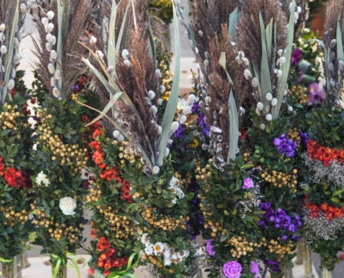 Palmsonntag Bedeutung: traditionelle Palmbuschen mit Palmkätzchen und Frühlingsblumen
