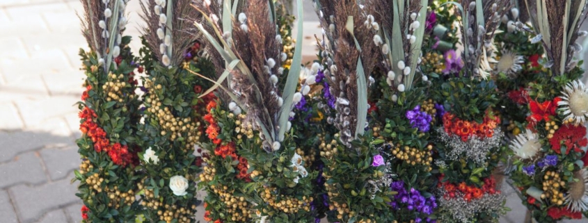 Palmsonntag Bedeutung: traditionelle Palmbuschen mit Palmkätzchen und Frühlingsblumen