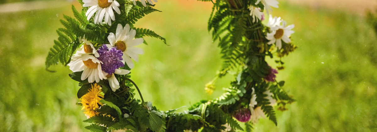 Blumenkranz aus Margeriten und Wiesenblumen als Symbol für Sommersonnenwende Rituale und den Jahreskreis