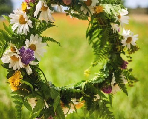 Blumenkranz aus Margeriten und Wiesenblumen als Symbol für Sommersonnenwende Rituale und den Jahreskreis